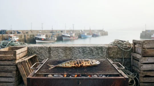 Maquereau entier grillé sur un barbecue en bois, ambiance portuaire bretonne au coucher du soleil